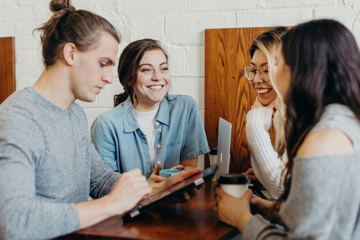 Four young adults catching up over coffee in a cafe