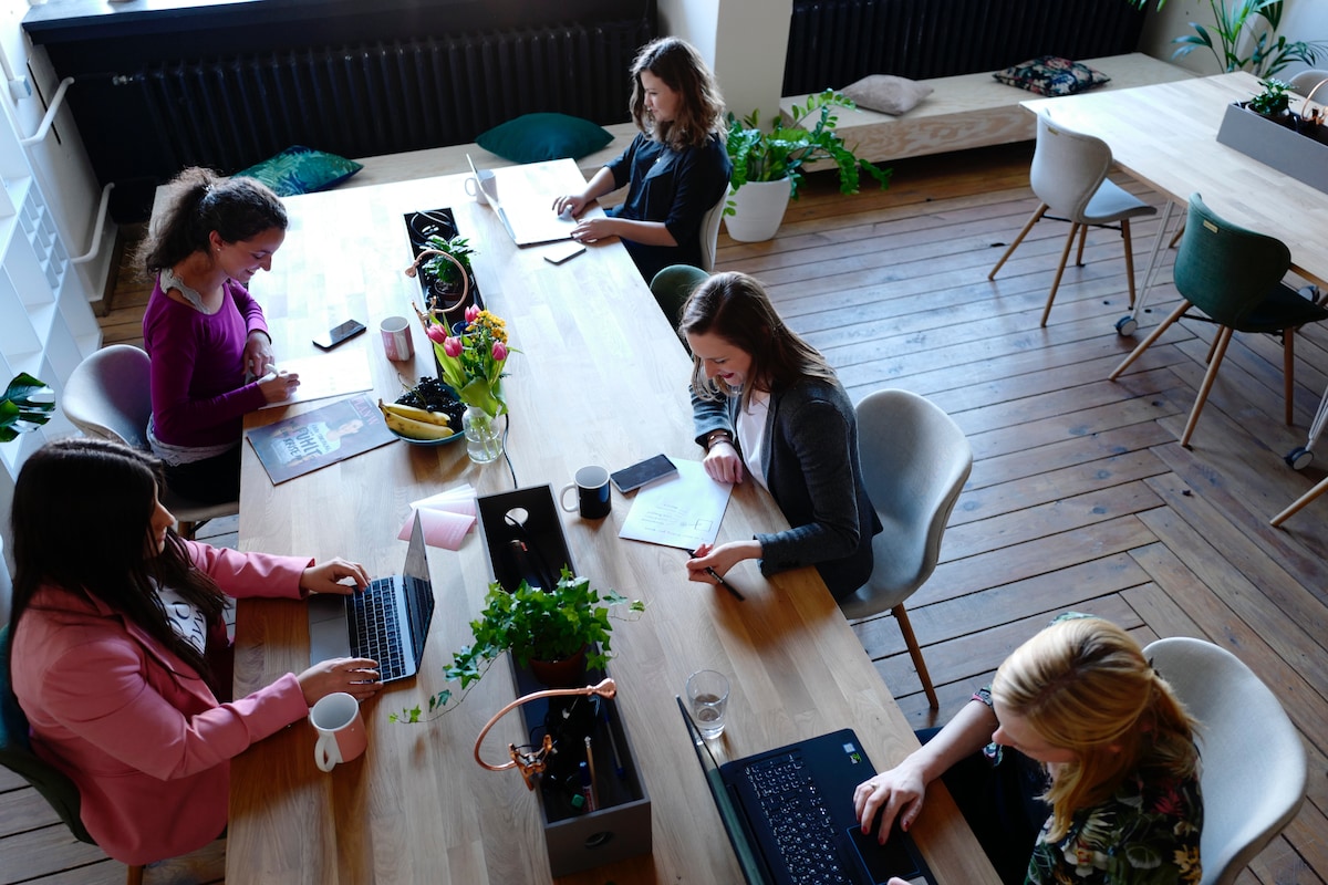 Women working at a table in an open plan office