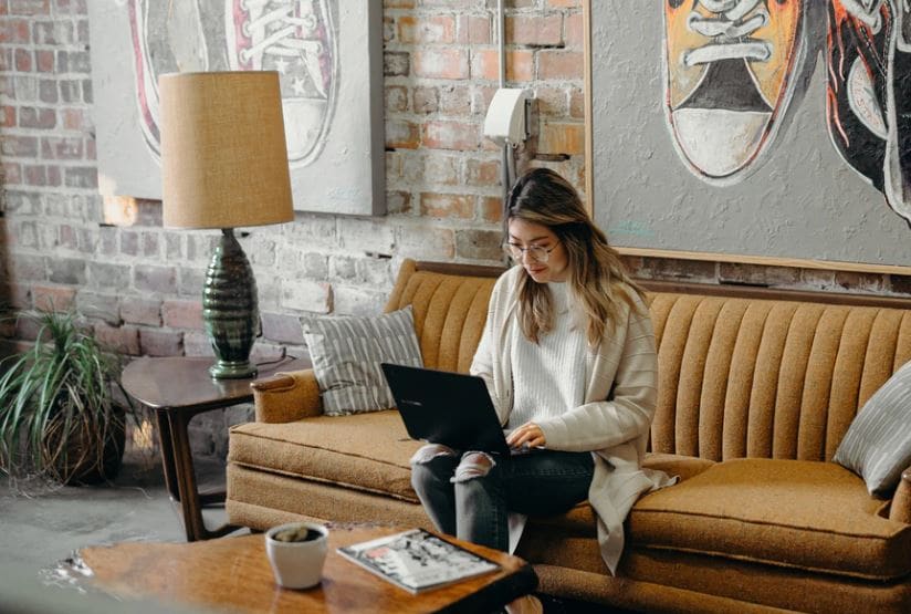 Young woman using laptop on her couch