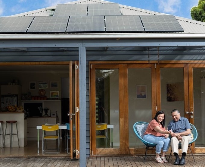 Grandparents sitting on back patio with rooftop solar