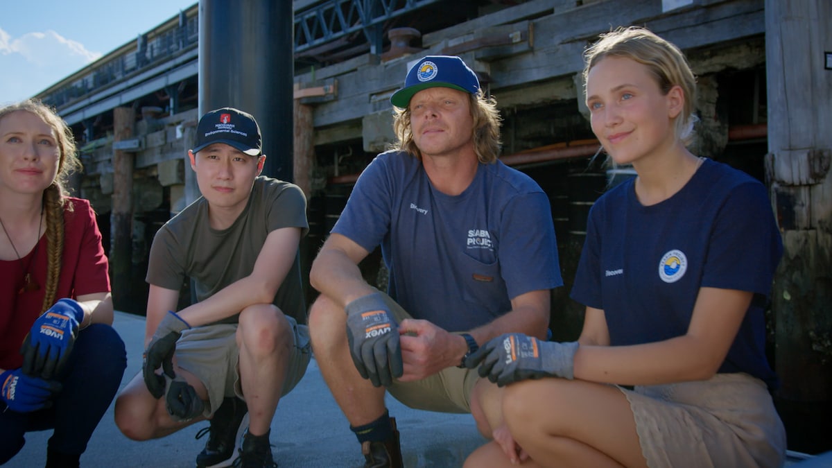 Seabin Project group crouching down together on boardwalk