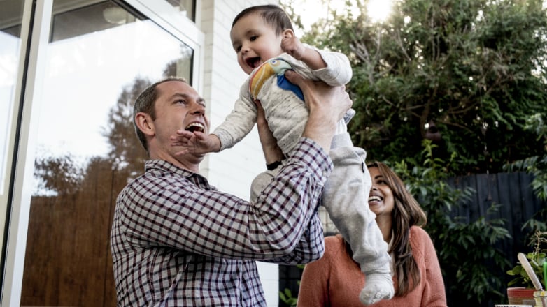 Husband and wife playing with their baby