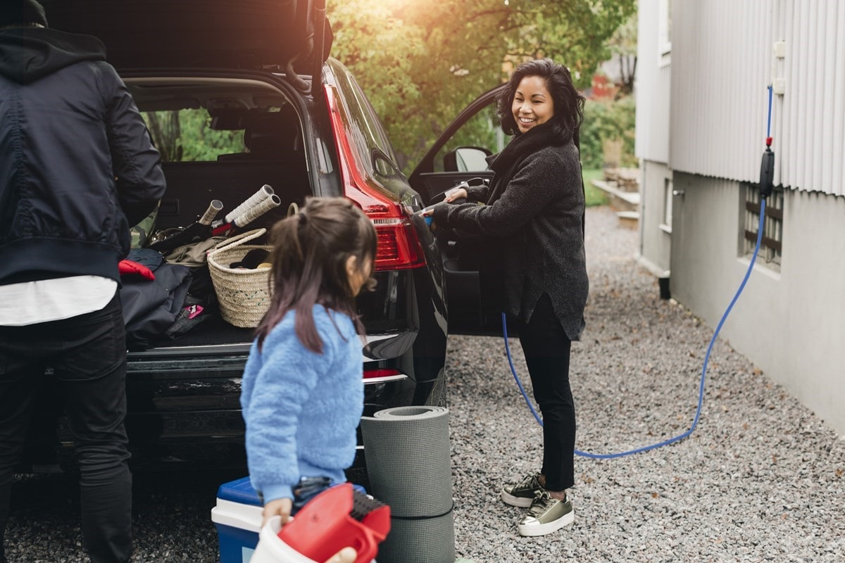 Family unpacking the family car while its charging