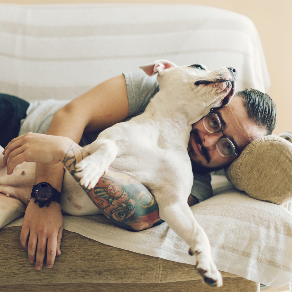 A man hugging his dog on the couch