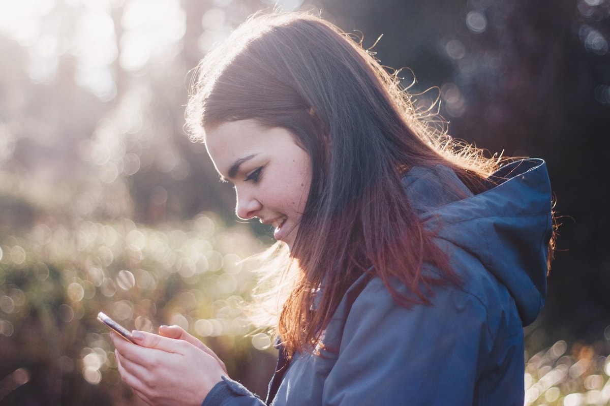 A woman scrolling on her phone outdoors