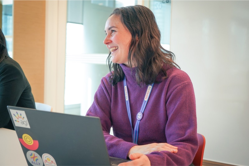 AGL employee with her sticker-covered laptop in a meeting. 