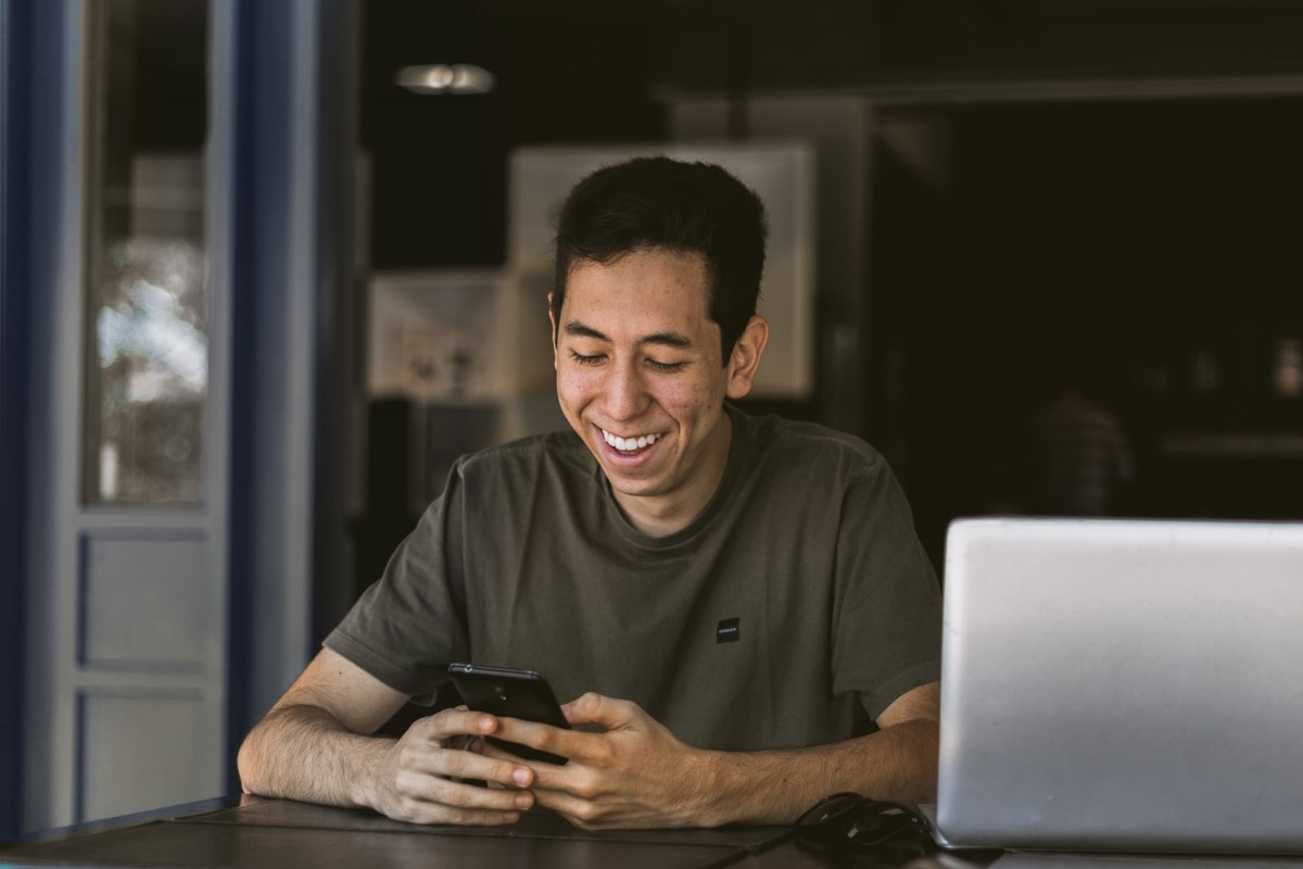 Smiling AGL employee with their sticker-covered laptop in a meeting