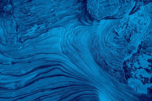 Textured blue rock layers forming a wavelike pattern.