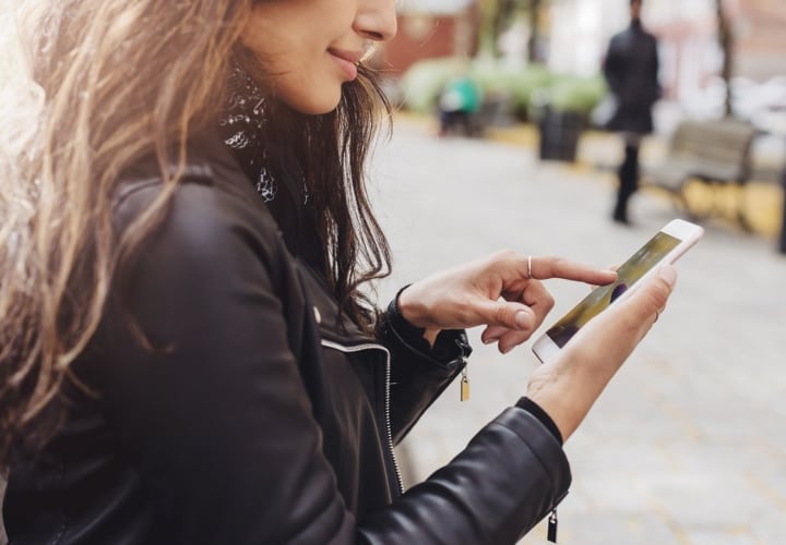 Young lady using phone on a walk