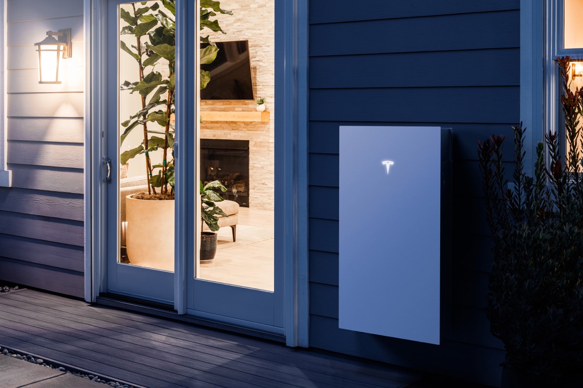 Photo of a Telsa Powerwall 3 battery installed by a door. 