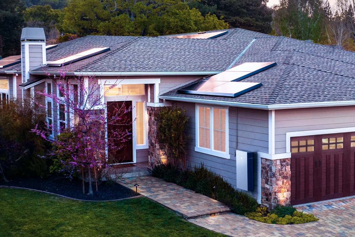 Photo of a Solar panels and a Telsa powerwall battery installed on a home. 